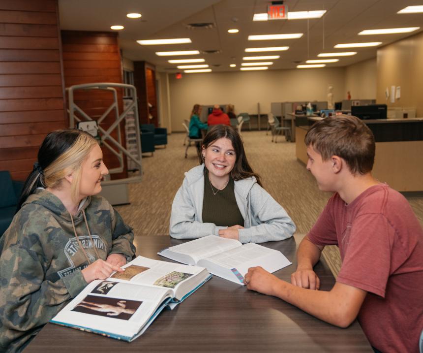 Three students study at a table