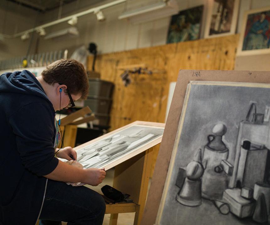 A student draws at an easel